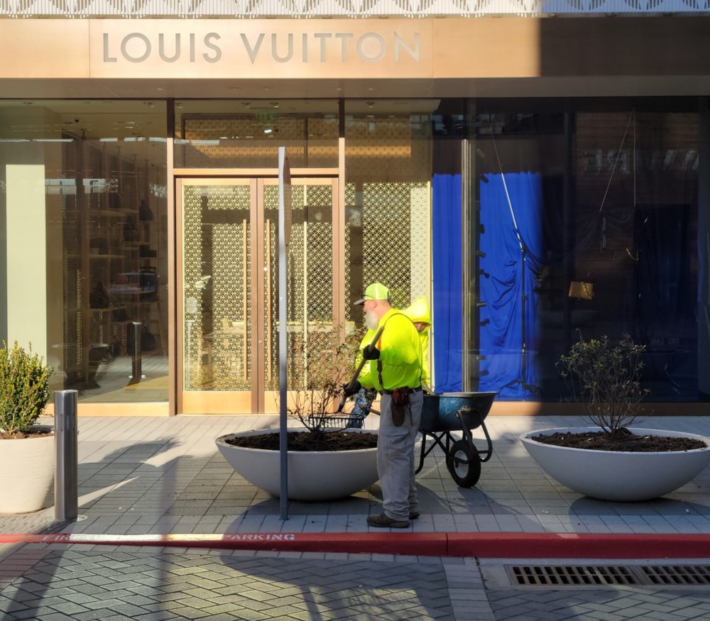 a man with a wheelbarrow in front of a building | Southern Botanical