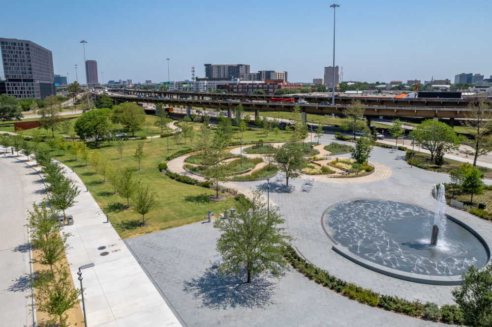 a park with a fountain and a train track | Southern Botanical