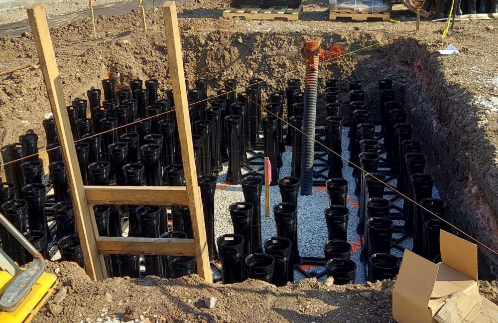 a pile of black plastic bottles sitting on top of a dirt field | Southern Botanical
