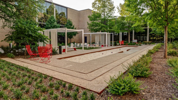 a red chair sitting in the middle of a courtyard | Southern Botanical