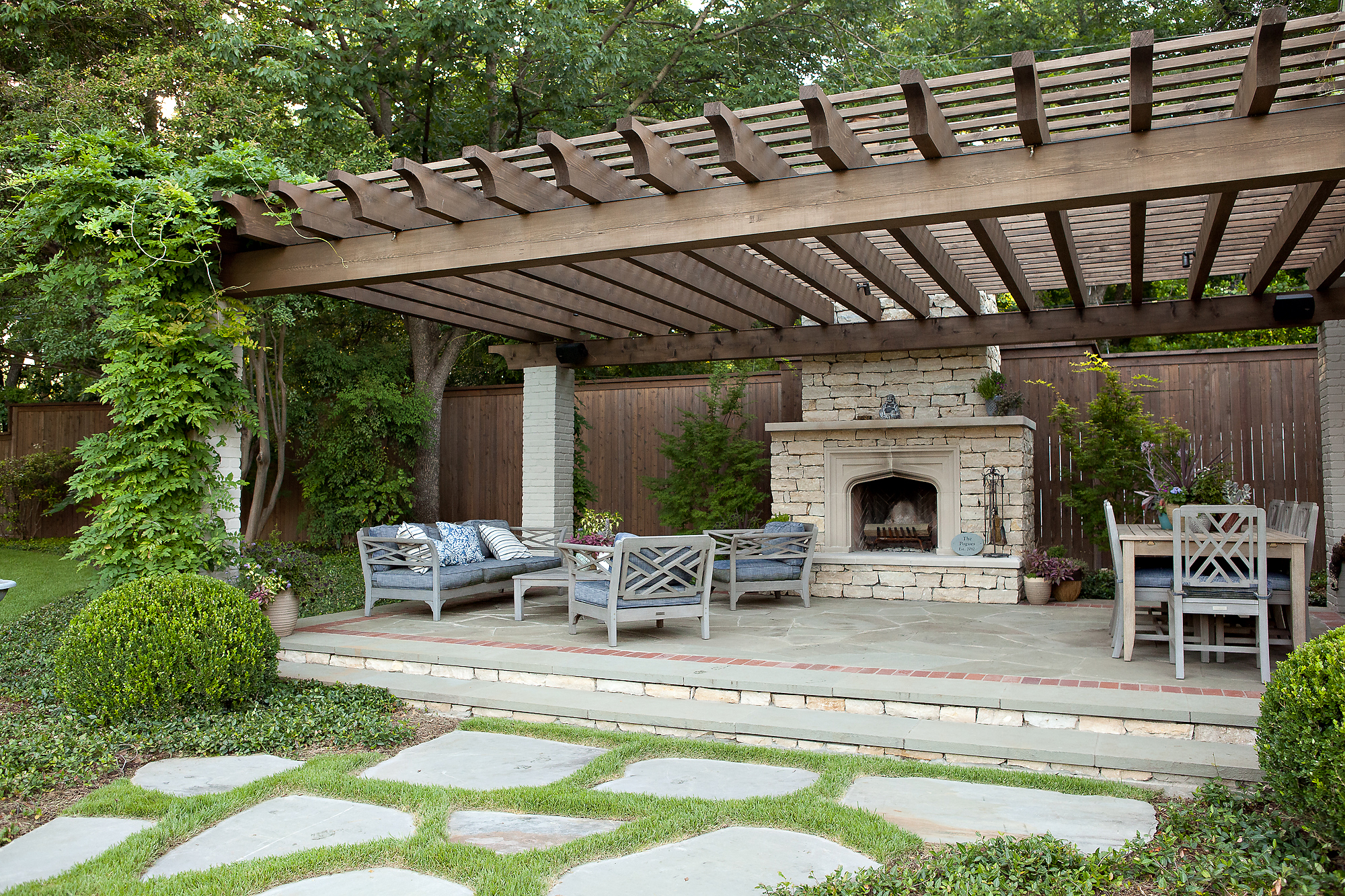 a patio with a fire place surrounded by greenery | Southern Botanical