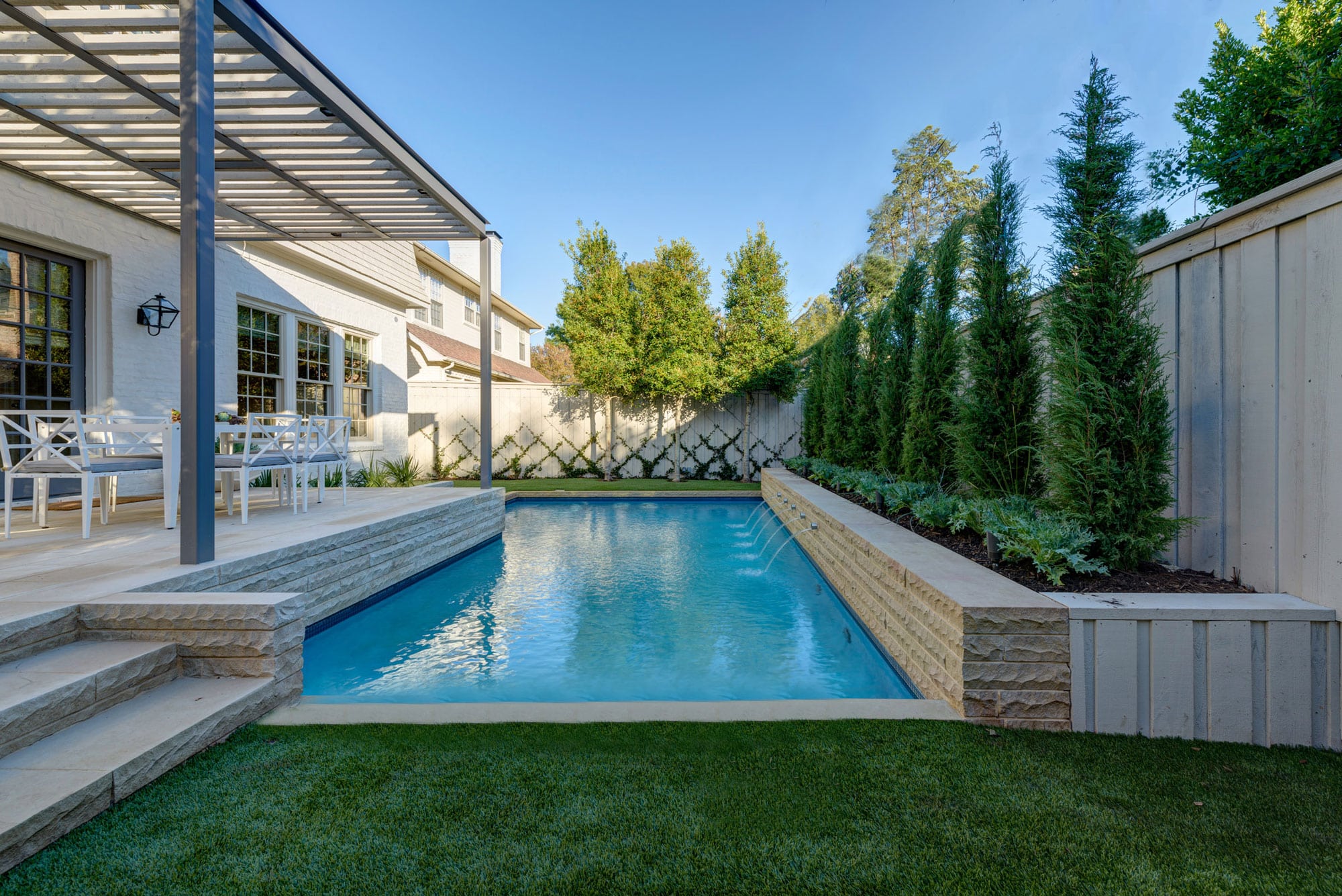 a backyard with a swimming pool and landscaping | Southern Botanical