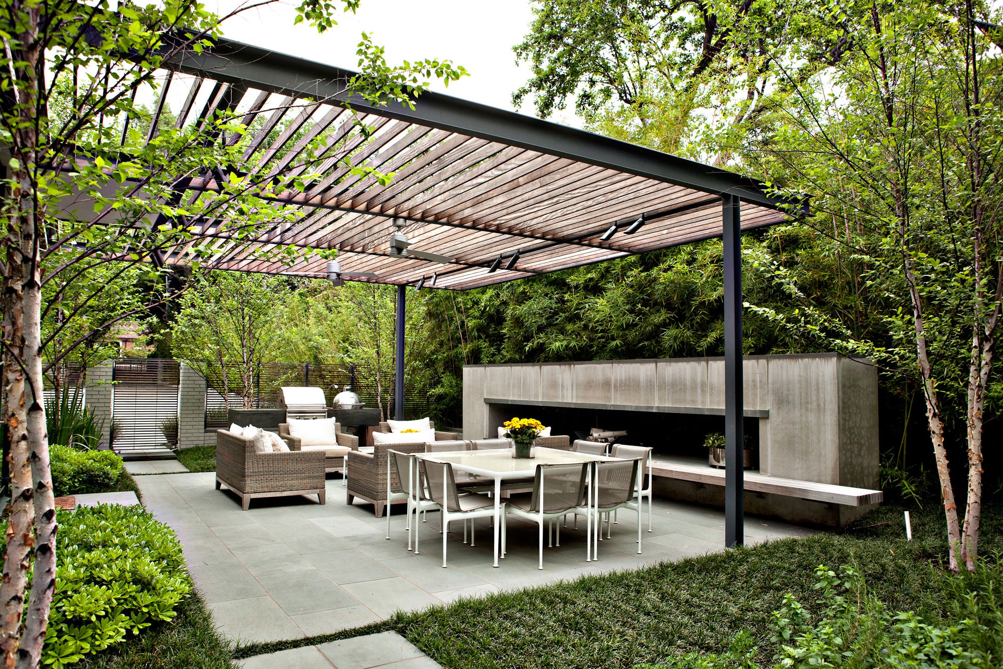 a patio with a table and chairs and a fire place | Southern Botanical