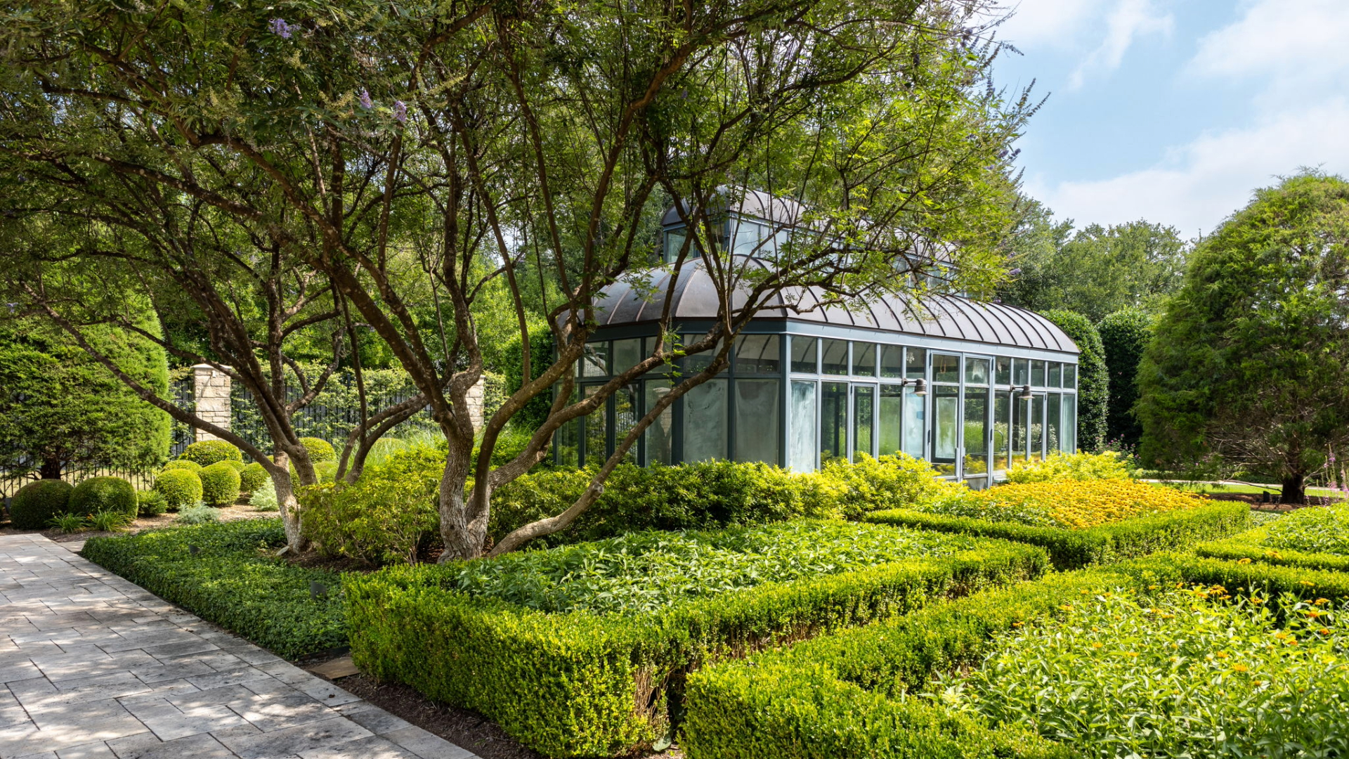 Backyard Greenhouse and English Garden with Perennials maintained by Southern Botanical